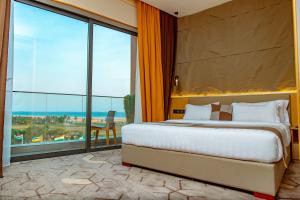 ein Schlafzimmer mit einem großen Bett und einem großen Fenster in der Unterkunft Bio Hôtel in Lomé