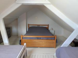 a bedroom with a wooden bed in a attic at GITE "LE VALLON DE PARAY" in Paray-le-Monial