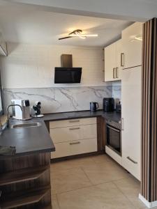 a kitchen with a sink and a counter top at Ferienhaus Holstein in Butjadingen