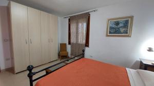 a bedroom with a bed with an orange blanket at Residence degli ulivi in Ossi