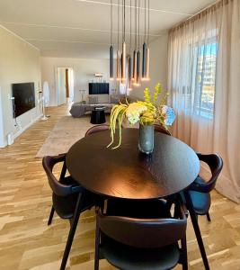 a dining room with a wooden table and chairs at Seafront Lux Apt, Central, Beach, Direct Airport Metro in Copenhagen