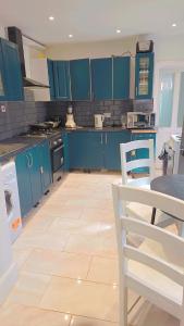 a kitchen with blue cabinets and a tile floor at Glory room ensuite in Slough +6 photos