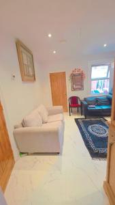 a living room with a couch and a bed at Glory room ensuite in Slough