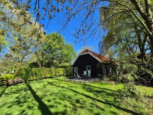 a small house in the middle of a yard at Gastenverblijf de Bloesem privé appartement in Lunteren +4 photos