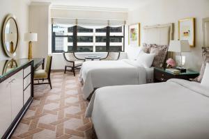 a hotel room with two beds and a table at Lotte New York Palace in New York