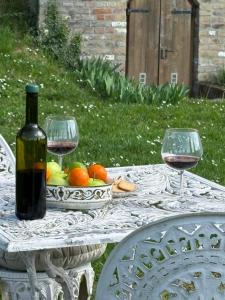 a table with a bottle of wine and two glasses at Vitál Guesthouse in Almamellék