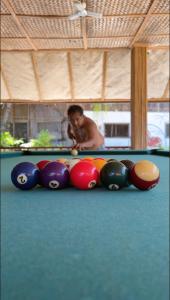 a man playing a game of pool on a pool table at D Mountain Beach Resort - Beachfront in Puerto Galera