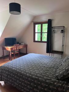 a bedroom with a bed and a desk and a window at Chambres d'hôtes les Boulommiers in Samois-sur-Seine +14 photos