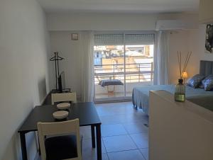 a bedroom with a bed and a table and a dining room at APARMENT Paraguay 341 in Rosario