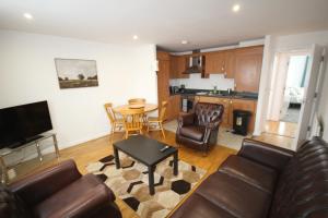a living room with a couch and a table at Bath Road Place in Harmondsworth