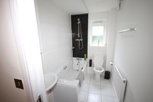 a white bathroom with a sink and a toilet at Bath Road Place in Harmondsworth +12 photos