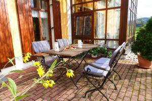 een houten tafel en stoelen op een patio met bloemen bij Ferienwohnung Beate Zierer in Eslarn