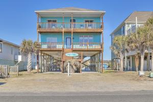 a blue building with palm trees in front of it at Life Is Good in Oak Island