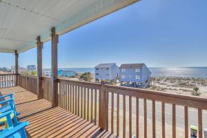 a balcony with blue chairs and the beach at Life Is Good in Oak Island