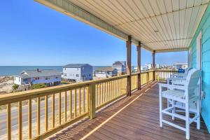 a deck with a chair and a view of the beach at Life Is Good in Oak Island