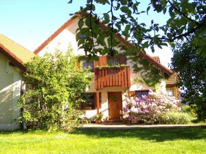 a house with a door and flowers in the yard at Ferienwohnung Beate Zierer in Eslarn