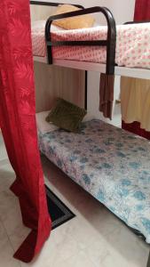 a room with two bunk beds with red curtains at km24 ALBERGUE in Padrón