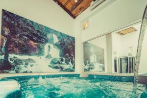 a jacuzzi tub in a room with paintings on the wall at Casa&Spa Don Gonzalo in Hoya-Gonzalo