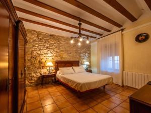 a bedroom with a bed and a stone wall at Casa&Spa Don Gonzalo in Hoya-Gonzalo +79 photos