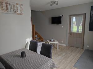 a dining room with a table and a television on the wall at GITE "LE VALLON DE PARAY" in Paray-le-Monial