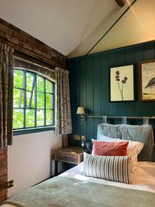 a bedroom with green walls and a bed and a window at Egypt Mill Hotel and Restaurant in Nailsworth