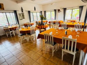 a dining room with tables and chairs and windows at Hotel Chez Fanny in Palimé