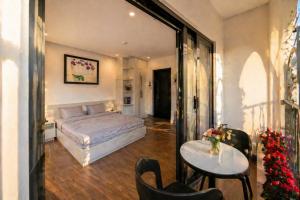 a bedroom with a bed and a table and chairs at Happy Life Hotel DaLat in Da Lat +5 photos