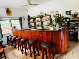 a bar with a bunch of stools in a room at Hotel Chez Fanny in Palimé