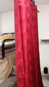 a red curtain in a room with a bed at km24 ALBERGUE in Padrón +11 photos