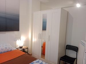 a bedroom with a white cabinet and a bed and a chair at Loft Centrico - Bahia 2B in Santander