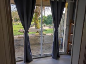a sliding glass door with a view of a deck at GITE "LE VALLON DE PARAY" in Paray-le-Monial