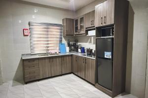a kitchen with wooden cabinets and a stainless steel refrigerator at Macdestly Apartments in Abuja