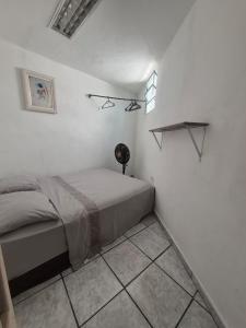 a bedroom with a bed in a white room at Nomad Hostel - Vila Madalena in São Paulo