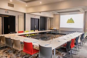 a conference room with tables and chairs and a projection screen at Lykke Hôtel & Spa Chamonix in Chamonix +79 photos