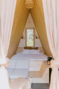 a bedroom with a large bed in a attic at Farouche Tremblant Cabines nature avec bain nordique in Lac-Superieur