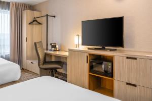 a hotel room with a television and a desk with a chair at Comfort Inn Alma - Lac-Saint-Jean in Alma