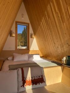 a large bed in a room with a window at Farouche Tremblant Cabines nature avec bain nordique in Lac-Superieur