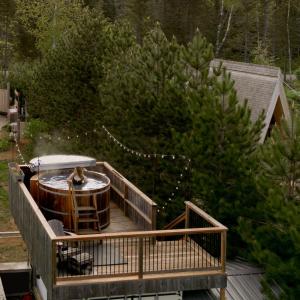 a deck with a hot tub on top of a house at Farouche Tremblant Cabines nature avec bain nordique in Lac-Superieur