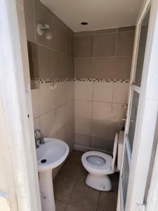 a bathroom with a toilet and a sink at Parvis Magna Hostal in Guaymallen
