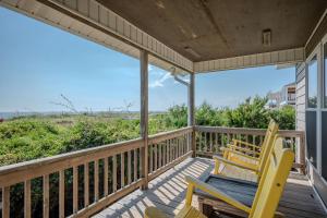 two chairs on a porch with a view of the ocean at Linger Longer in Caswell Beach