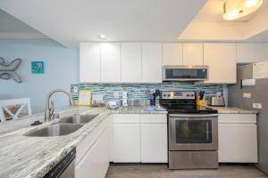 a kitchen with a sink and a stove top oven at Wind Drift 615N condo in Orange Beach