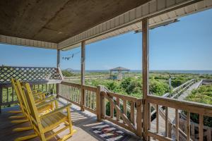 a porch with two chairs and a view of the ocean at Linger Longer in Caswell Beach