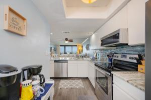 a kitchen with white cabinets and a stove top oven at Wind Drift 615N condo in Orange Beach