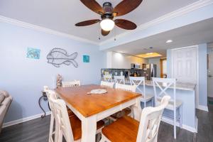 a dining room with a table and chairs and a ceiling fan at Wind Drift 615N condo in Orange Beach