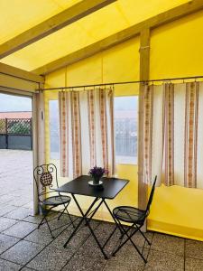 a table and chairs on a balcony with a window at Affittacamere Cà Bianca in Casa Rossa