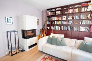 a living room with a white couch and a book shelf at Eksklusiv og sjarmerende leilighet på Frogner in Oslo