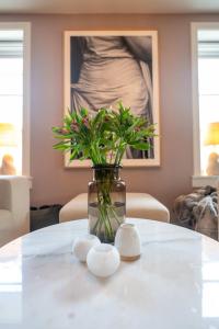a vase with flowers sitting on a table at Eksklusiv og sjarmerende leilighet på Frogner in Oslo