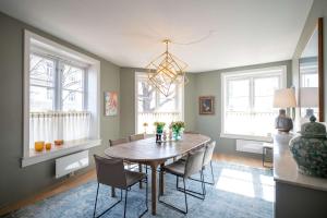 a dining room with a table and chairs and windows at Eksklusiv og sjarmerende leilighet på Frogner in Oslo