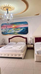 a bedroom with a bed and a painting on the wall at Villa Kliven in Durrës