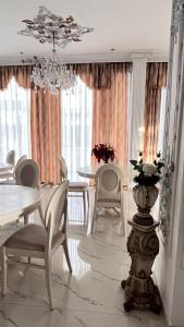 a dining room with tables and chairs and a chandelier at Villa Kliven in Durrës